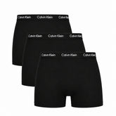 Three pairs of black Calvin Klein boxer briefs on a white background