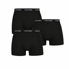 Three black Calvin Klein boxer briefs on a white background