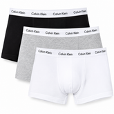 Three pairs of Calvin Klein men's boxer briefs in black, heather gray, and white, arranged in a diagonal stack on a plain white background.
