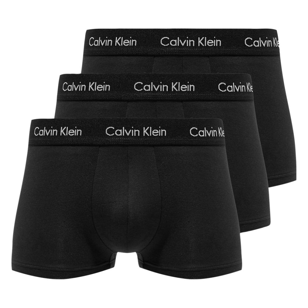 Three black Calvin Klein low-rise trunks with Calvin Klein branding on the waistband.