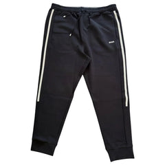 Black jogger pants with white side stripes and a small white BOSS logo on the left thigh, shown flat against a light beige background.