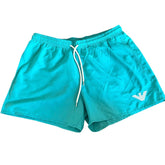 Turquoise blue swim shorts with a white drawstring and a white embroidered eagle logo on the lower left leg, displayed flat against a white background.