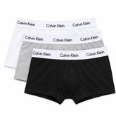 Three pairs of Calvin Klein boxer briefs stacked in a fan arrangement on a white background, featuring black, light gray, and white fabrics with white elastic waistbands printed with the Calvin Klein brand name.