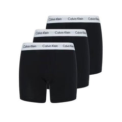 Three pairs of black Calvin Klein boxer briefs arranged in a staggered stack, showing the white waistband with the black brand name.