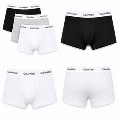 Six pairs of Calvin Klein men's boxer briefs arranged in a 3x2 grid, showing black, white, and heather gray options with the brand name printed on the waistband.