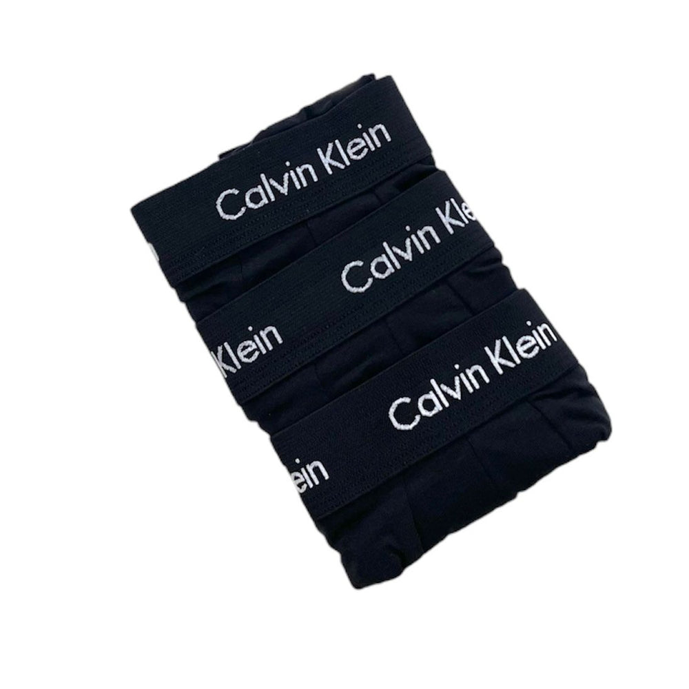 Four folded pairs of black Calvin Klein briefs stacked diagonally, showing the white brand name printed repeatedly on the waistbands against a plain white background.