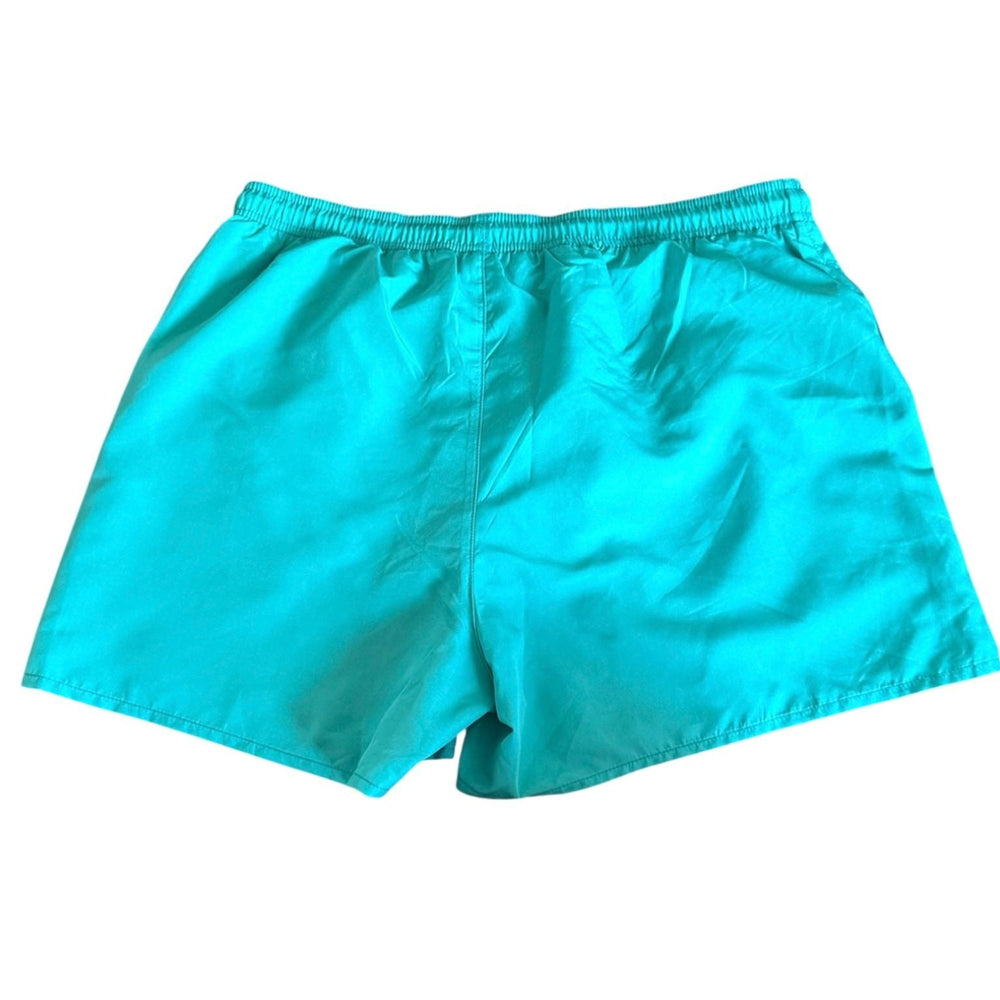 Turquoise blue swim trunks with an elastic waistband, laid flat against a white background.