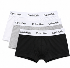 Three pairs of Calvin Klein boxer briefs stacked in a fan arrangement on a white background, featuring black, light gray, and white fabrics with white elastic waistbands printed with the Calvin Klein brand name.