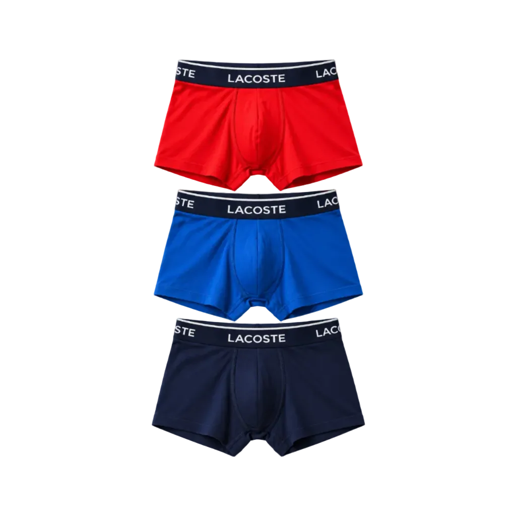 Three pairs of Lacoste men's boxer briefs stacked vertically on a white background, featuring red, royal blue, and navy blue fabrics with black waistbands and white brand lettering.