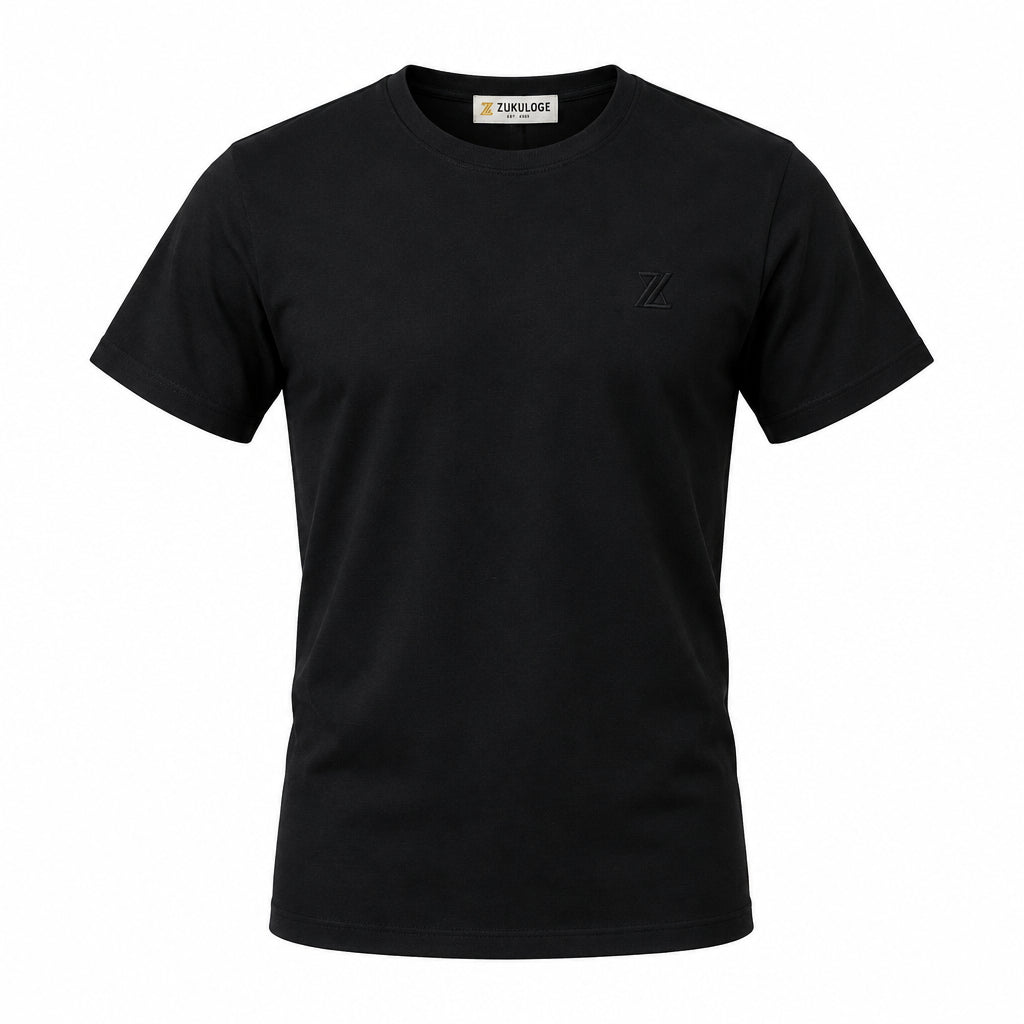A black short-sleeve crewneck t-shirt by ZUNDOOZ London, featuring a small tonal embroidered logo on the left chest and a black hangtag attached to the collar, displayed on a clean white background.